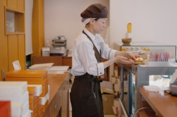 ショーケースからケーキを取り出す店員さん